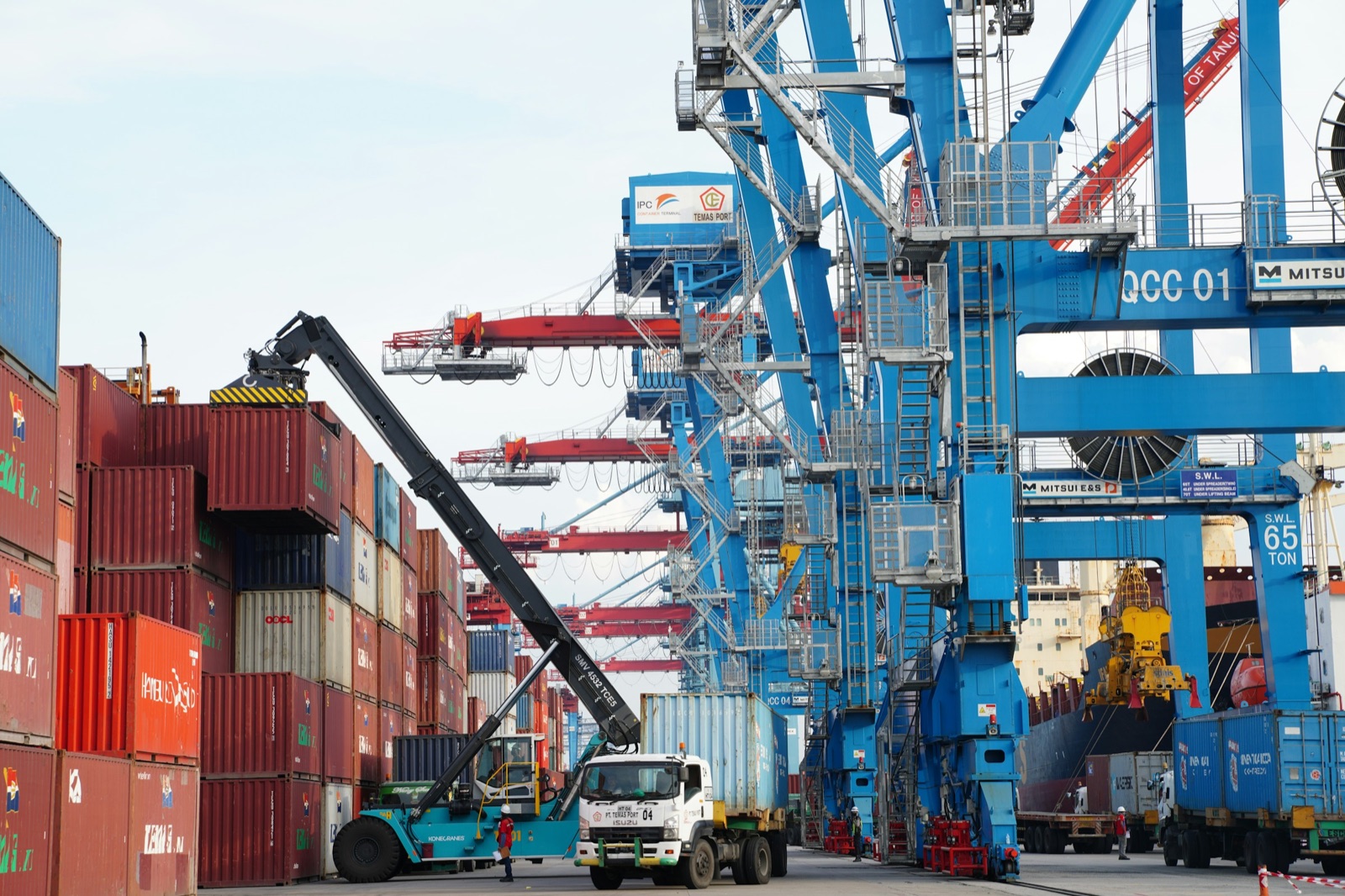 Ship-to-shore cranes and stacked containers at a Southeast Asian container terminal