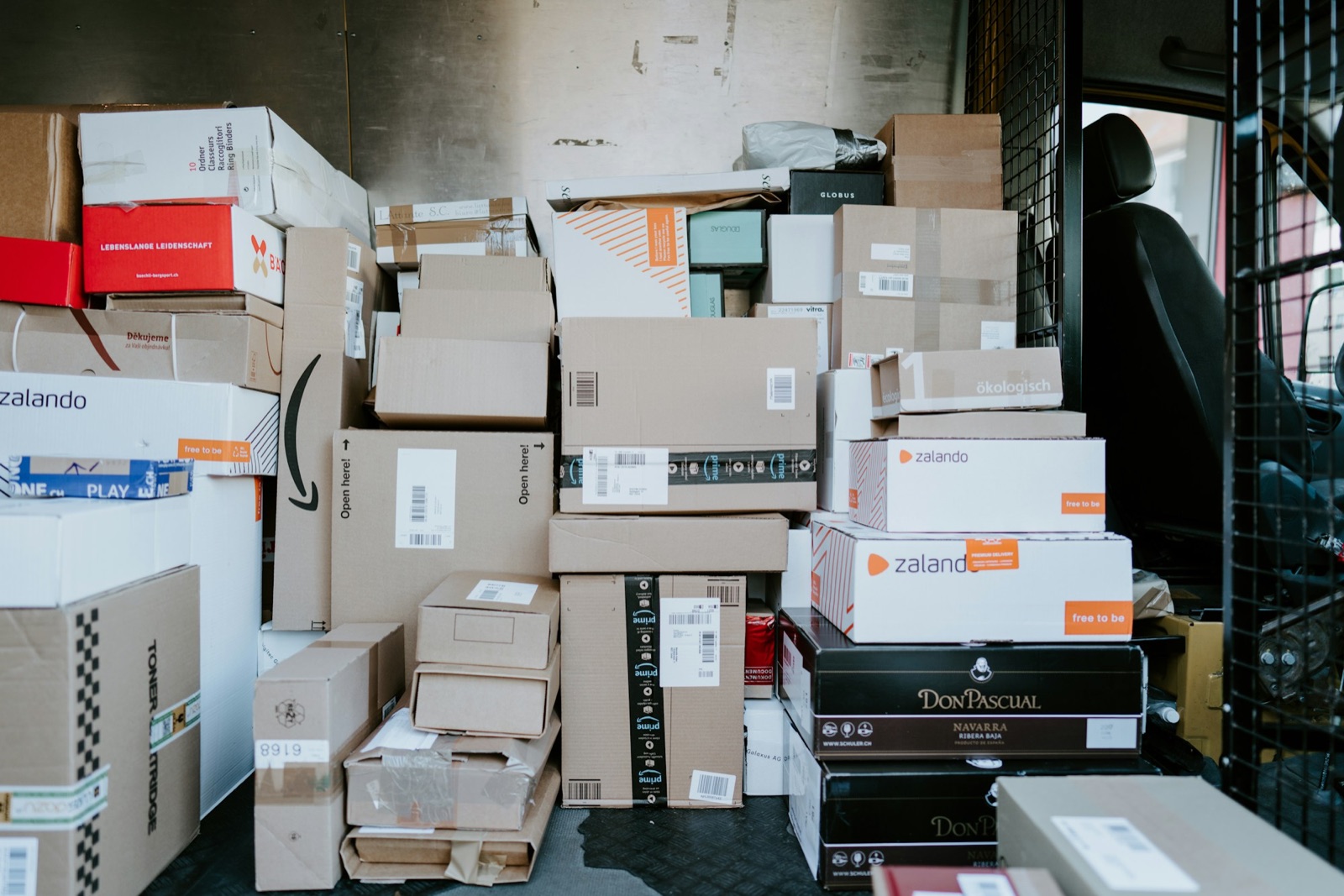 Stack of e-commerce parcels inside a delivery van