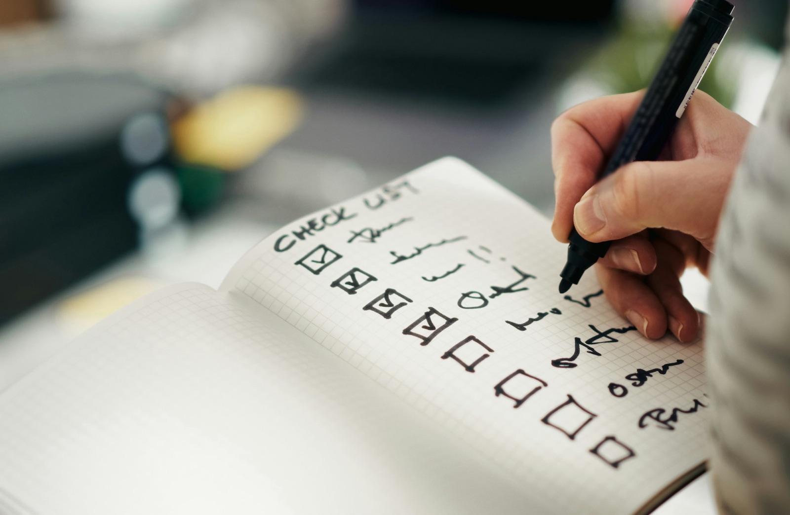 Hand ticking items on a handwritten checklist
